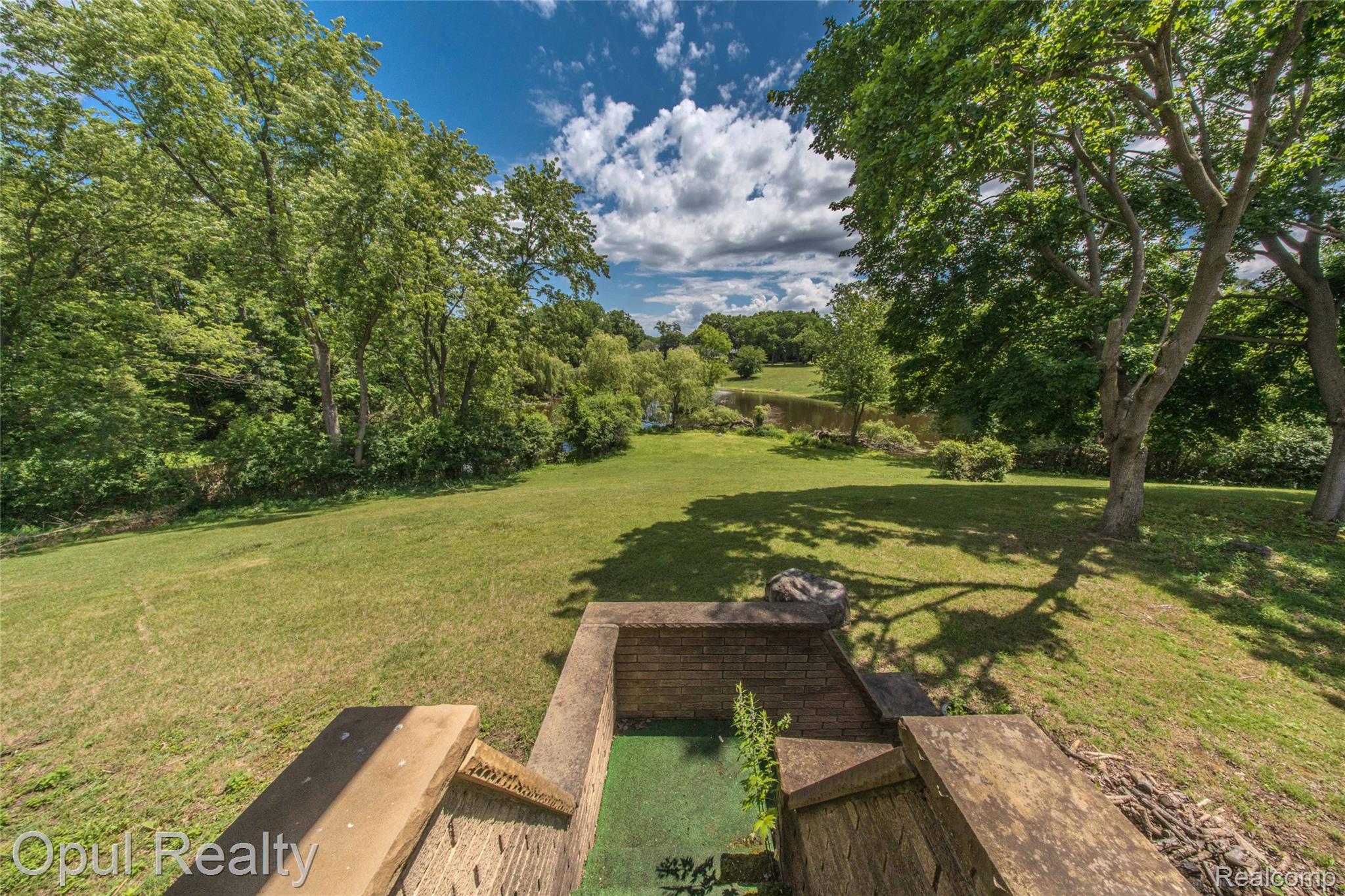 6455 Norham Road Bloomfield Hills, MI 48301 - Photo 10 of 93 Expansive green space featuring mature trees and a distant body of water