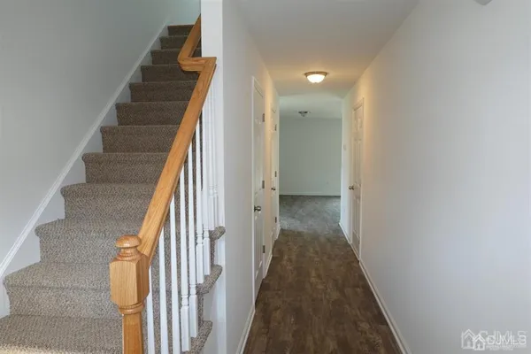 a view of a hallway with wooden floor and entryway