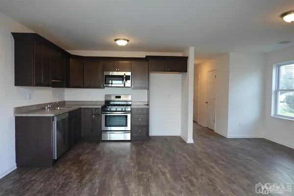 a kitchen with stainless steel appliances kitchen island granite countertop a stove and a refrigerator