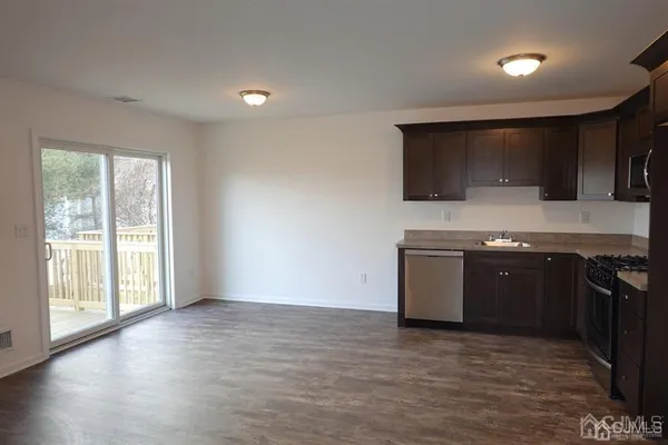 a kitchen with a stove and a wooden floor