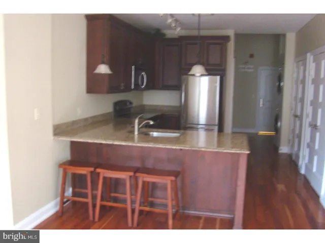 a kitchen with kitchen island a sink stainless steel appliances and cabinets