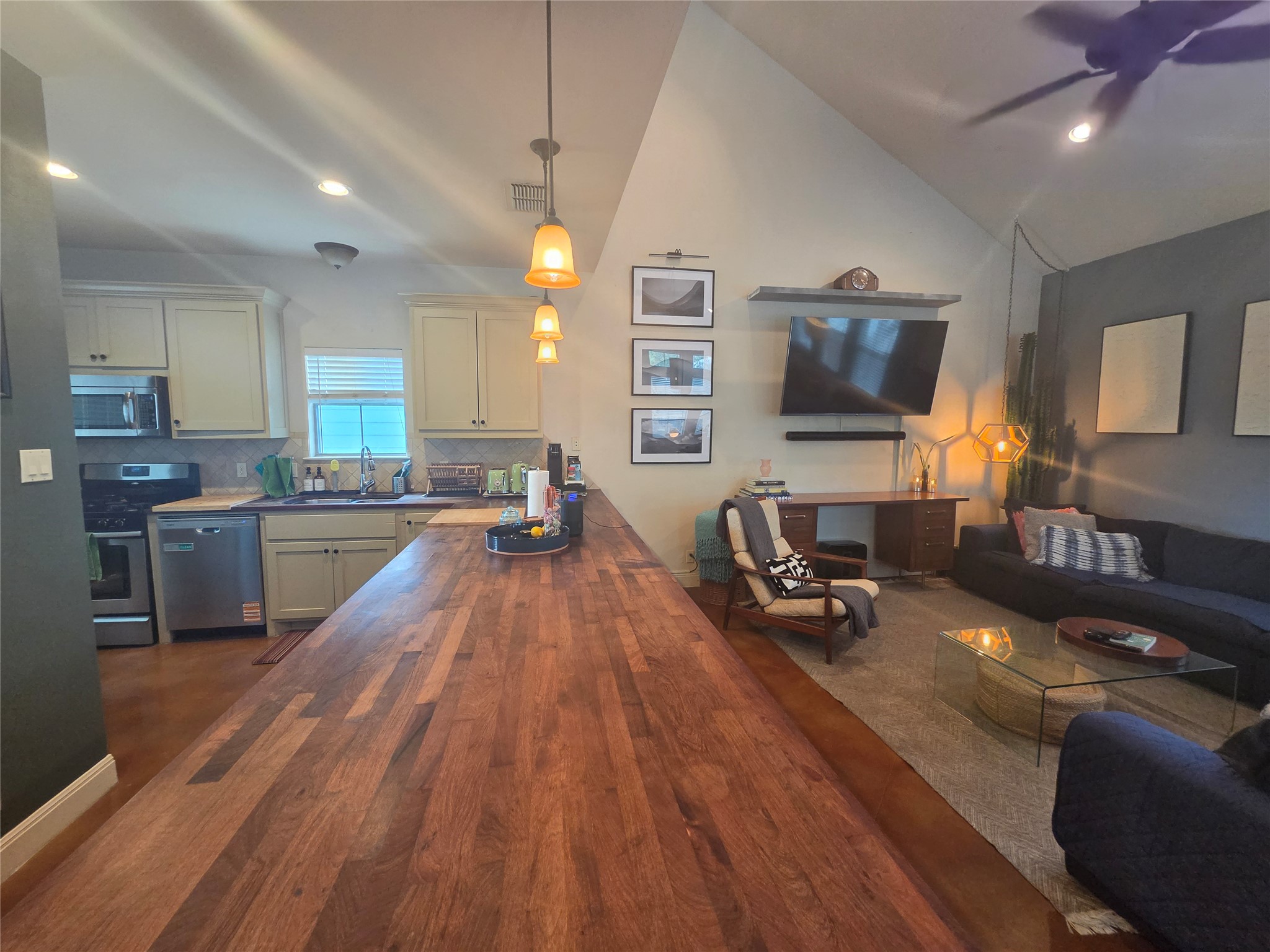 408 West Croslin Street Austin, TX 78752 - Photo 29 of 29 An open concept floorplan features a modern kitchen flowing into a spacious living area with vaulted ceilings.