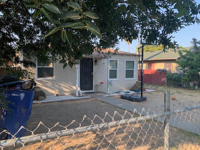a view of a white house with a large tree