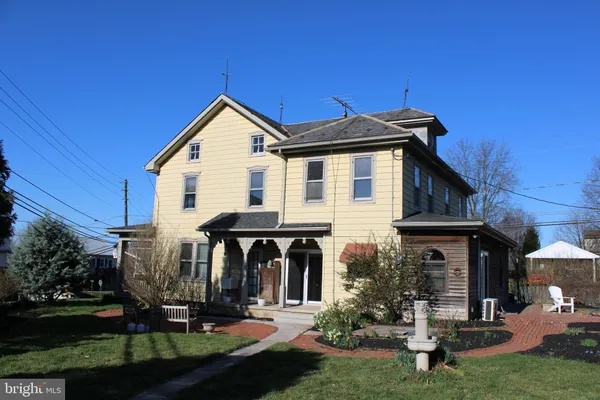 a view of a house with yard and porch