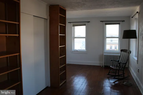 an empty room with wooden floor and a window