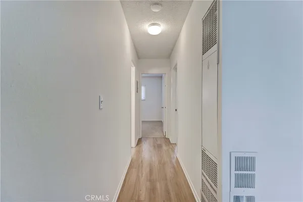 a view of a hallway with wooden floor