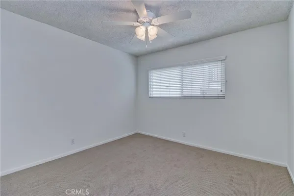 an empty room with a window and a fan