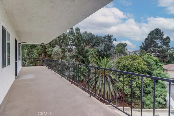 a view of a balcony with trees in front of it