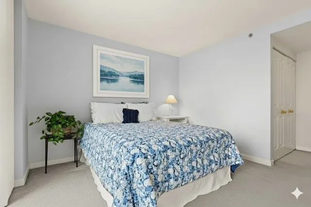 a bedroom with a bed and a painting on the wall