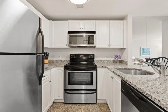 a kitchen with granite countertop a sink stove and refrigerator