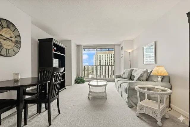 a living room with furniture a flat screen tv and a floor to ceiling window