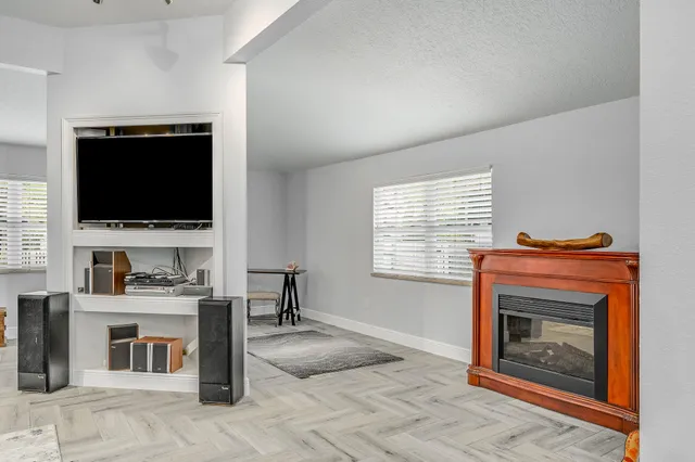 a living room with furniture a flat screen tv and a fireplace