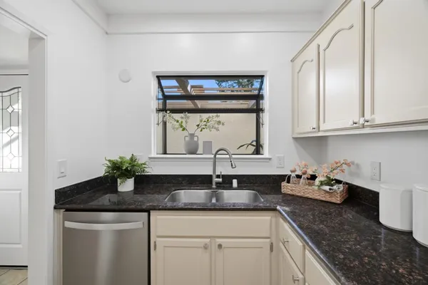 a kitchen with stainless steel appliances granite countertop a sink and a window
