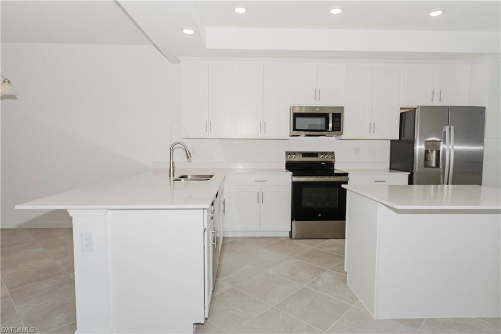 5583 Double Eagle Circle, Unit 4125 Ave Maria, FL 34142 - Photo 2 of 36 a kitchen with a refrigerator a stove and a sink