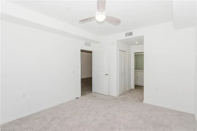 an empty room with a ceiling fan and a bathroom