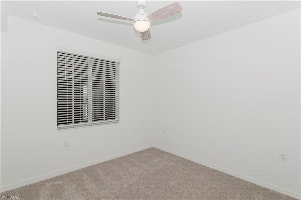 5583 Double Eagle Circle, Unit 4125 Ave Maria, FL 34142 - Photo 7 of 36 en empty room with windows and ceiling fan