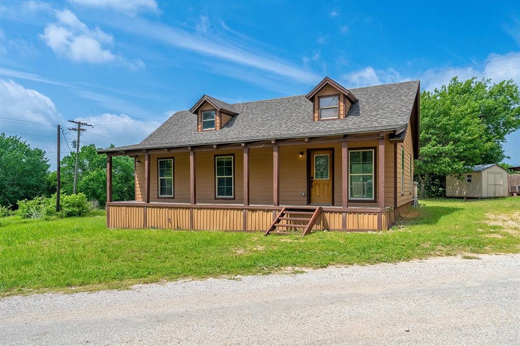 371 Spring Street Forestburg, TX 76239 - Photo 4 of 38 a front view of a house with a yard and trees