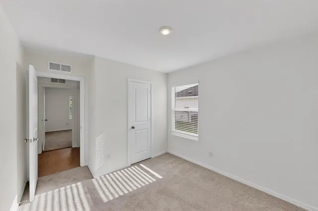 a view of a room with a closet and wooden floor