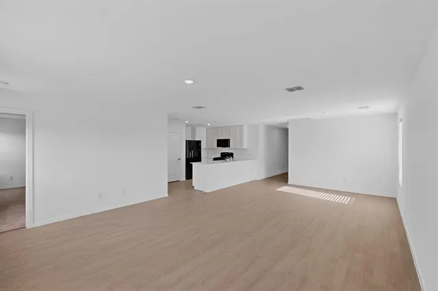 a view of empty room with kitchen
