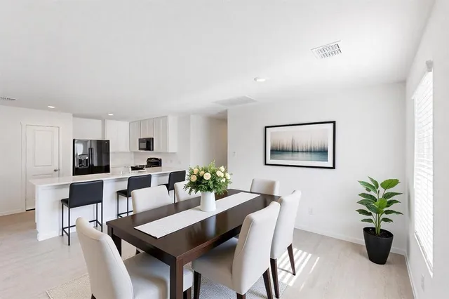 a dining room with furniture and potted plants