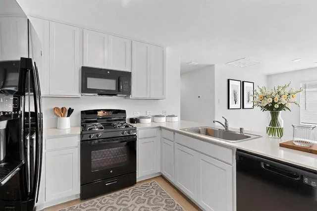 a kitchen with a sink appliances and cabinets