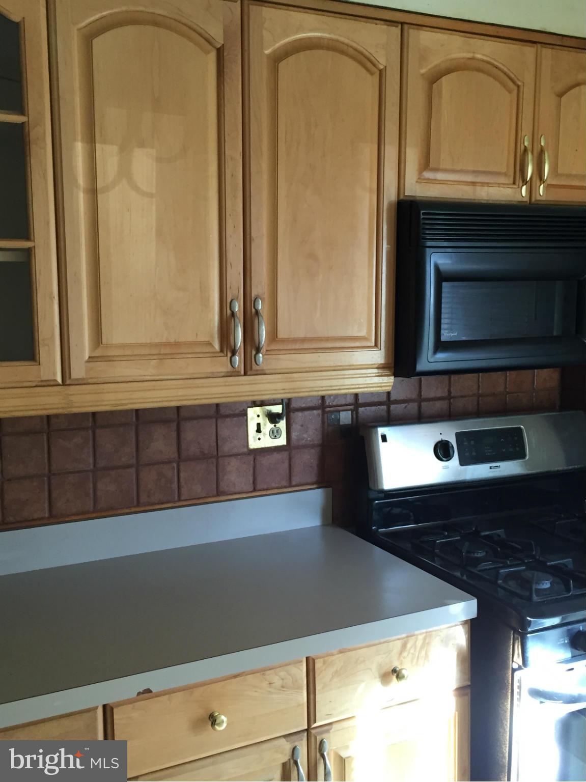 6127 Marlora Road Baltimore, MD 21239 - Photo 11 of 27 a kitchen with granite countertop white cabinets and black appliances