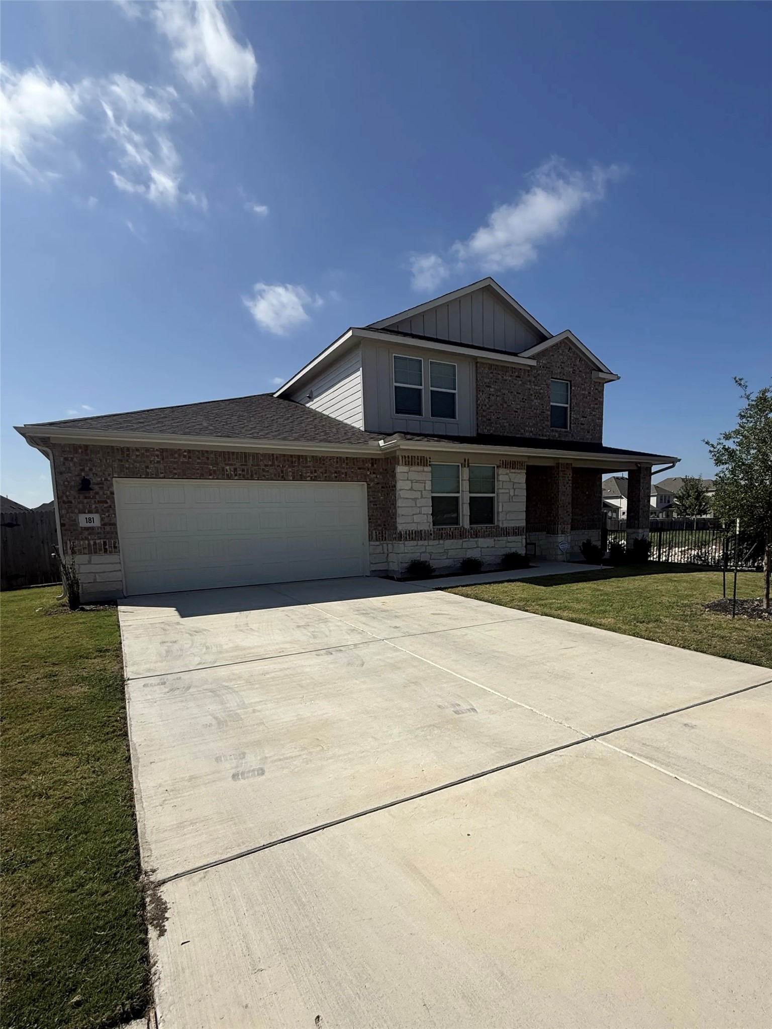 181 Old Town Road Kyle, TX 78640 - Photo 2 of 4 A well-maintained facade showcasing brick and stone accents, complemented by a broad concrete driveway.