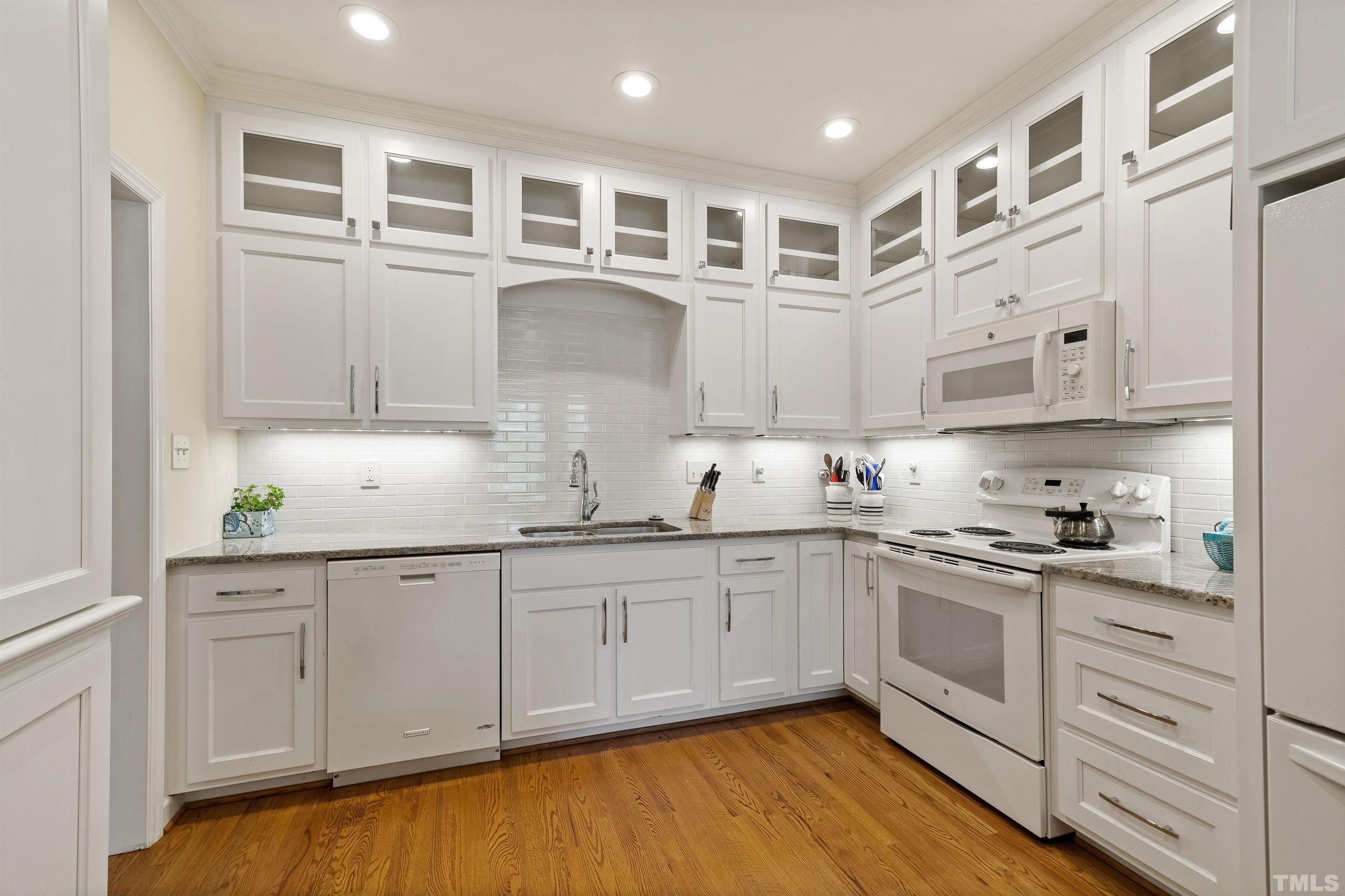 2623 Ashland Street Raleigh, NC 27608 - Photo 3 of 18 a kitchen with cabinets wooden floor and stainless steel appliances