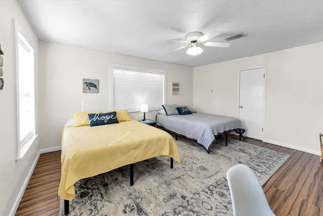 a spacious bedroom with a bed a window and potted plant