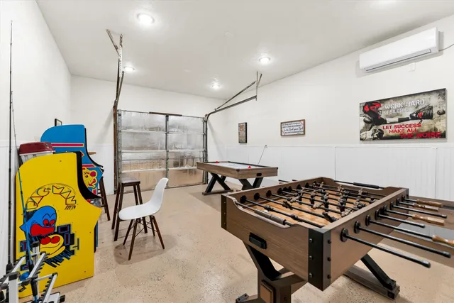 a living room with furniture pool table and windows
