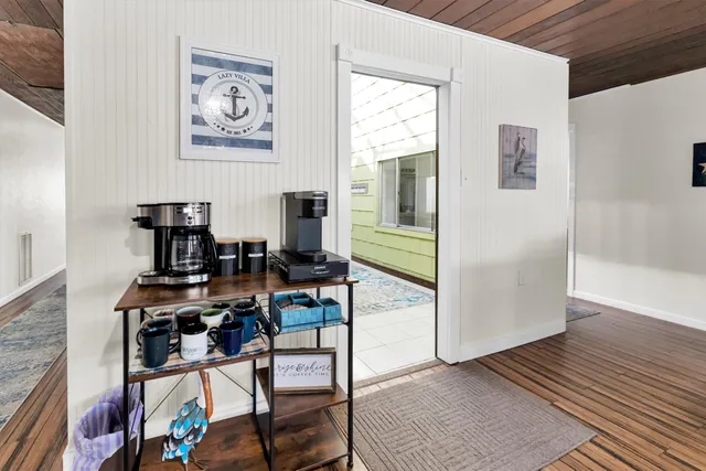 a living room with stainless steel appliances furniture a fireplace and kitchen view