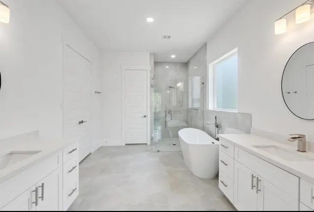 a spacious bathroom with a double vanity sink toilet mirror and bathtub