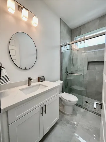 a bathroom with a toilet a sink and a mirror