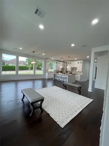 a living room with dining room and wooden floor