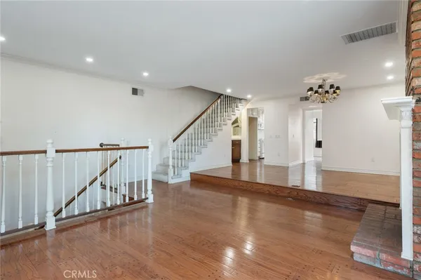a view of a hallway with wooden floor and staircase