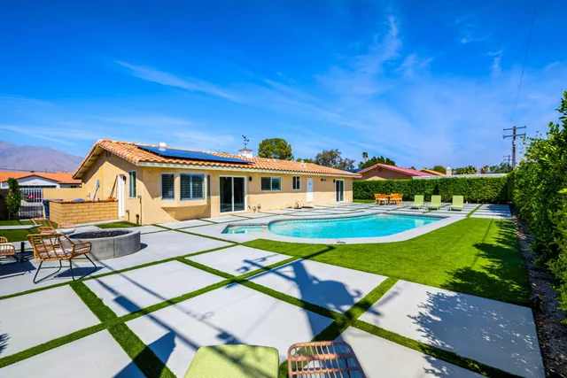 a front view of a house with swimming pool having outdoor seating