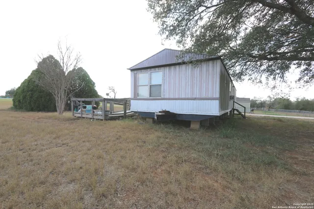 a view of a house with backyard and trees