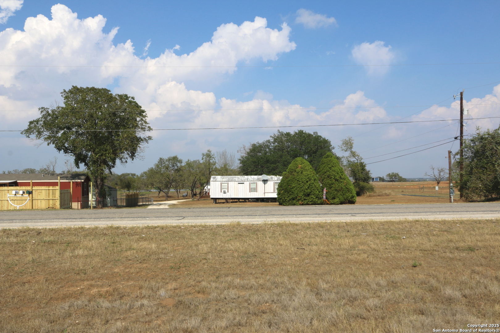 13847 Highway 87 Adkins, TX 78101 - Photo 4 of 23 a front view of a house with a yard and garage