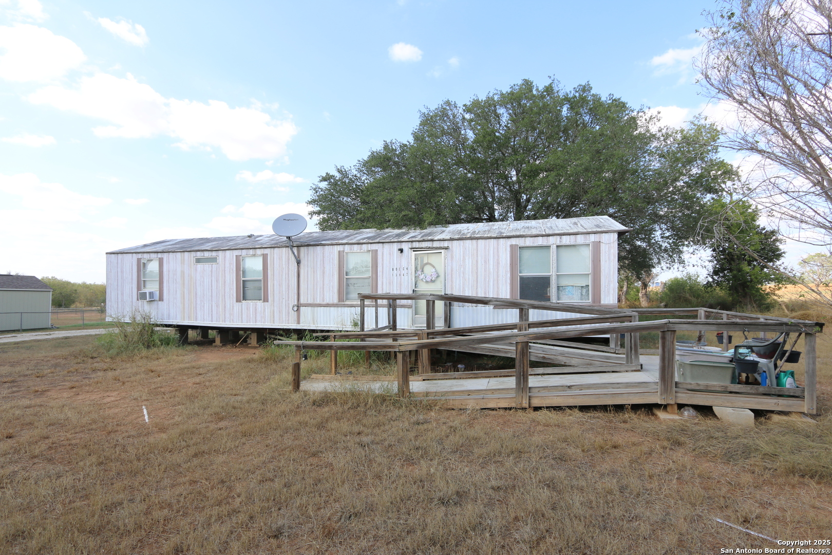 13847 Highway 87 Adkins, TX 78101 - Photo 9 of 23 a view of a white house with wooden fence