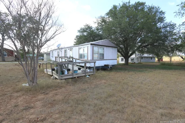 a view of a house with a yard and sitting area