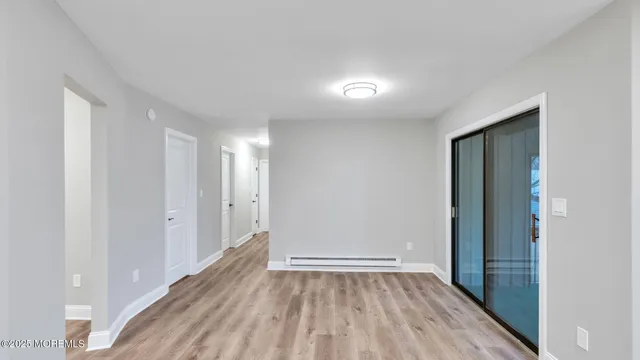 a view of an empty room with wooden floor