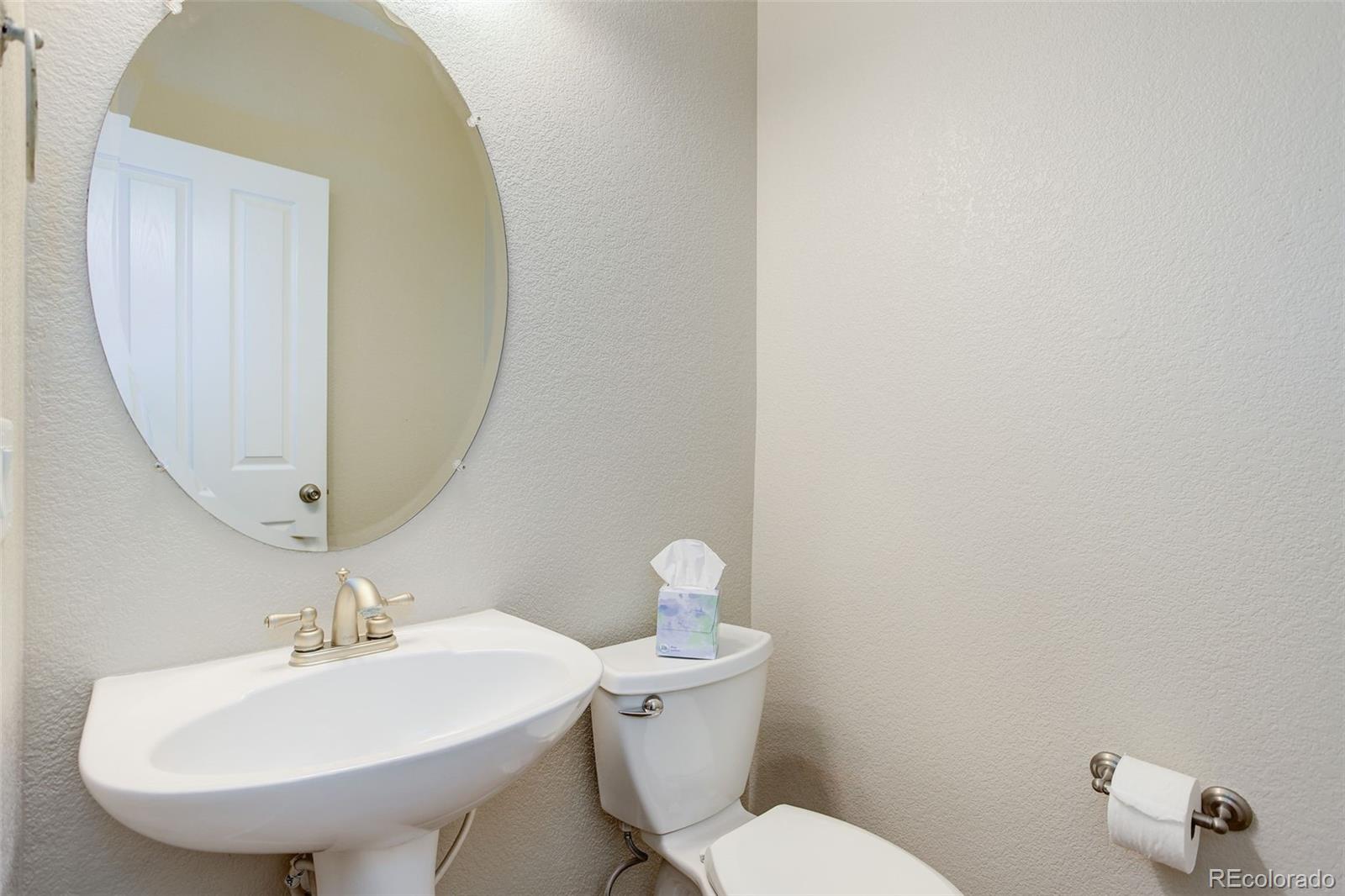 674 Bristle Pine Circle, Unit D Highlands Ranch, CO 80129 - Photo 29 of 31 a bathroom with a sink a toilet and mirror