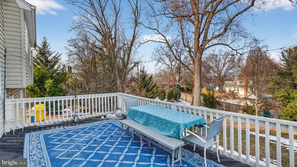 a view of a bench in roof deck with wooden fence and floor