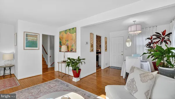 a living room with furniture potted plant and wooden floor