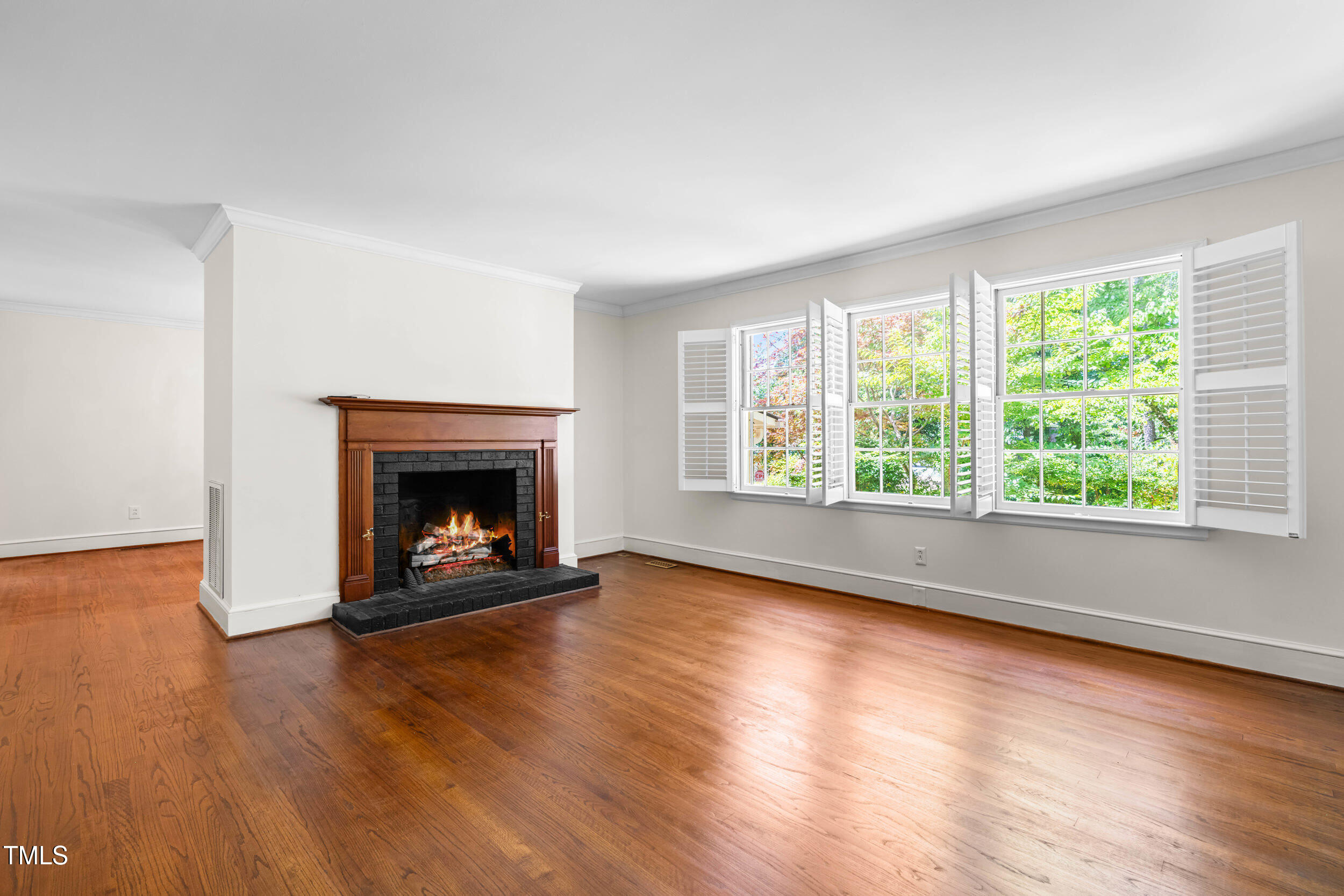 2143 Ridge Road Raleigh, NC 27607 - Photo 11 of 40 an empty room with wooden floor fire place and windows
