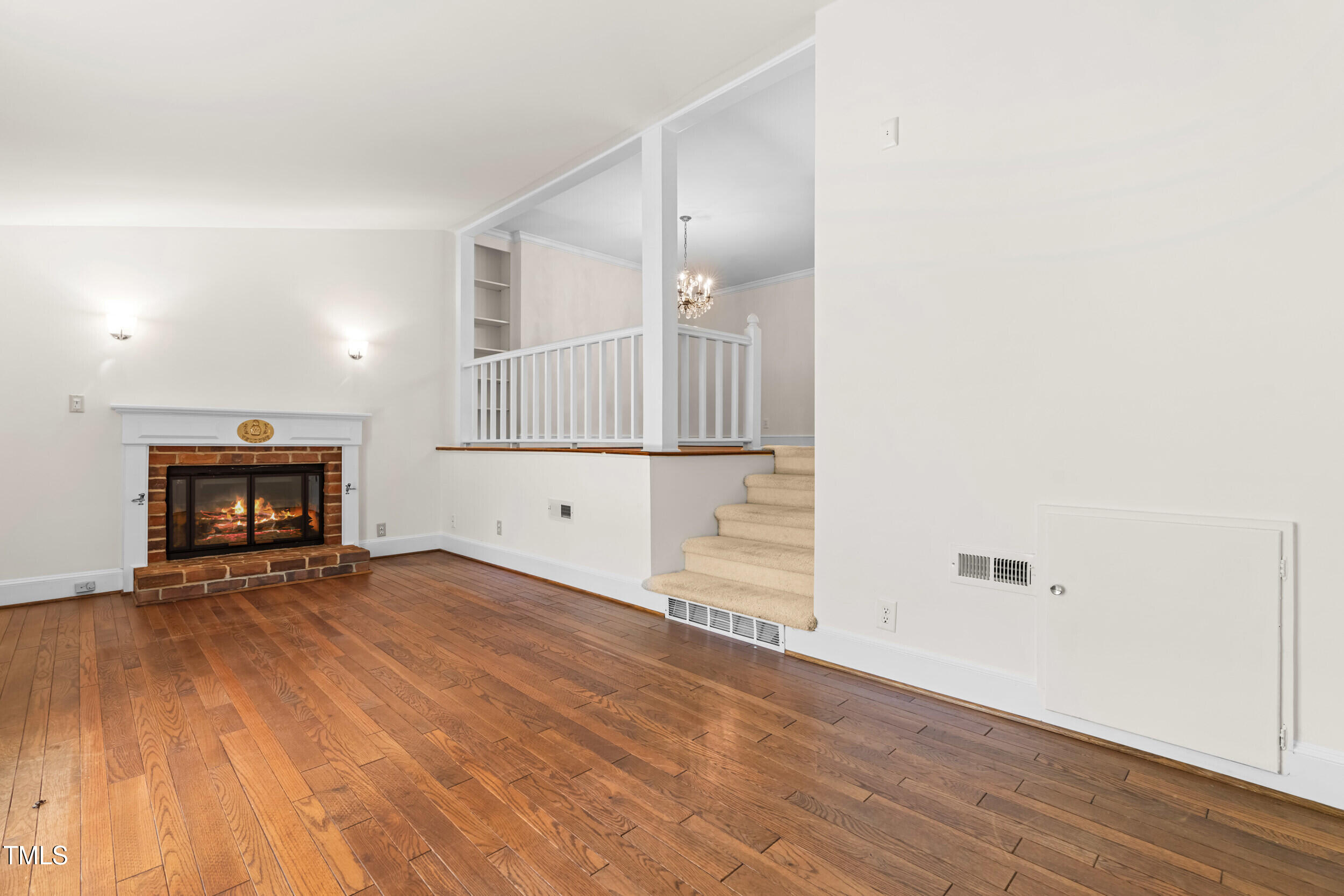 2143 Ridge Road Raleigh, NC 27607 - Photo 19 of 40 an empty room with wooden floor and fireplace
