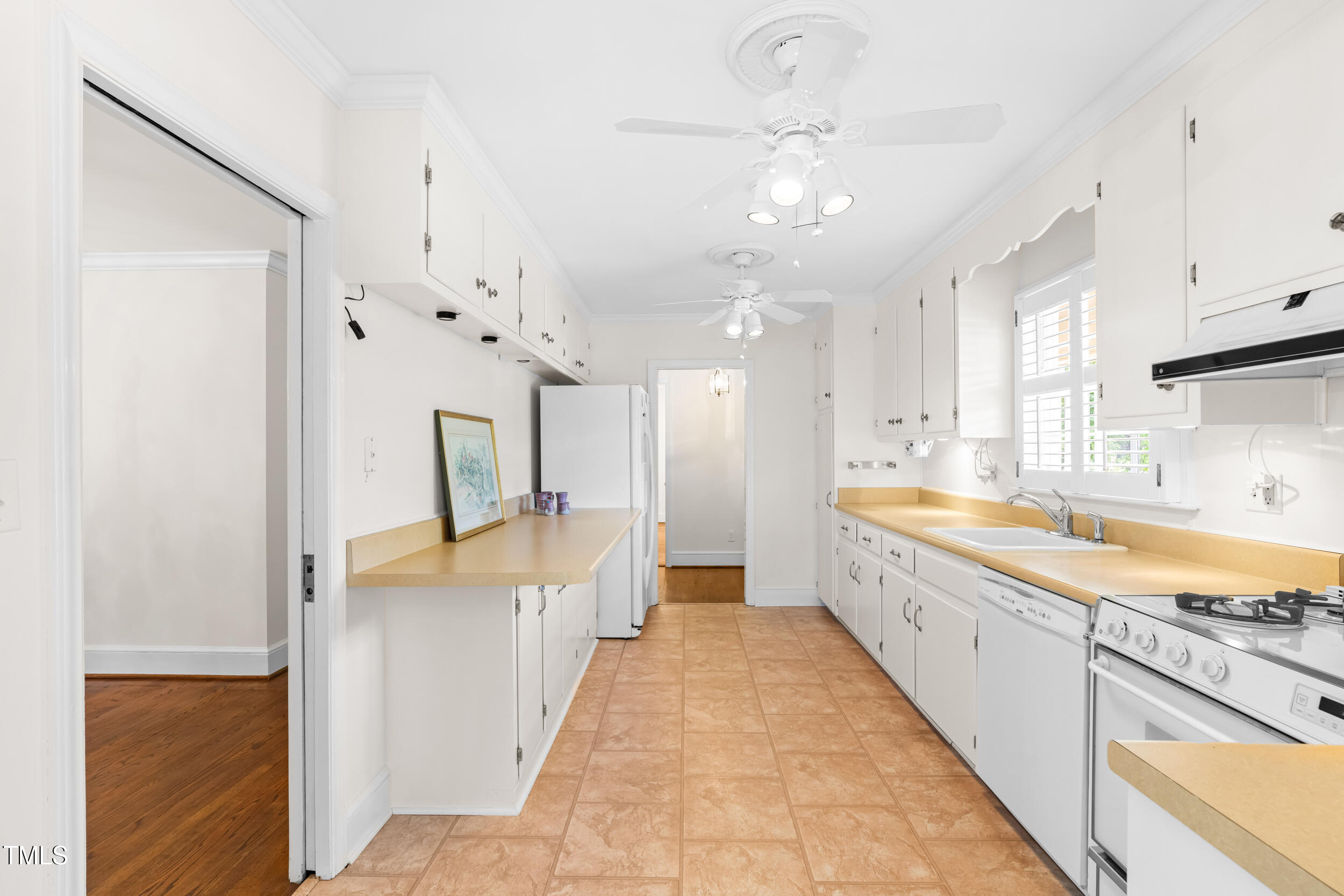 2143 Ridge Road Raleigh, NC 27607 - Photo 22 of 40 a large white kitchen with kitchen island a large counter space a sink stainless steel appliances and cabinets