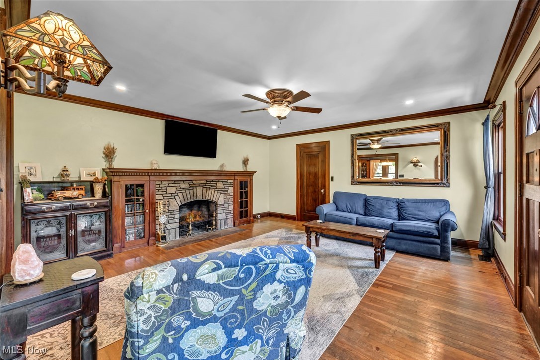 7550 Mayfield Road Chesterland, OH 44026 - Photo 12 of 45 Living room with wood finished floors, ornamental molding, a fireplace, recessed lighting, and a ceiling fan