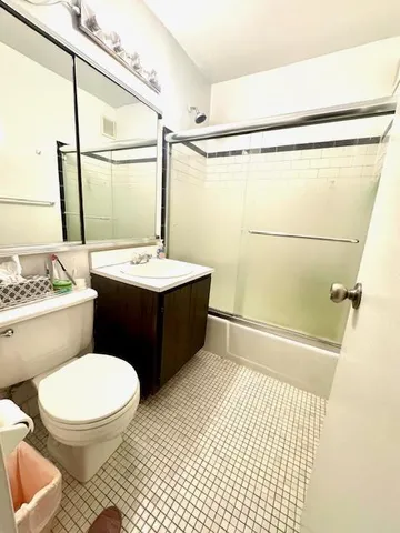 a bathroom with a sink a toilet a mirror and shower