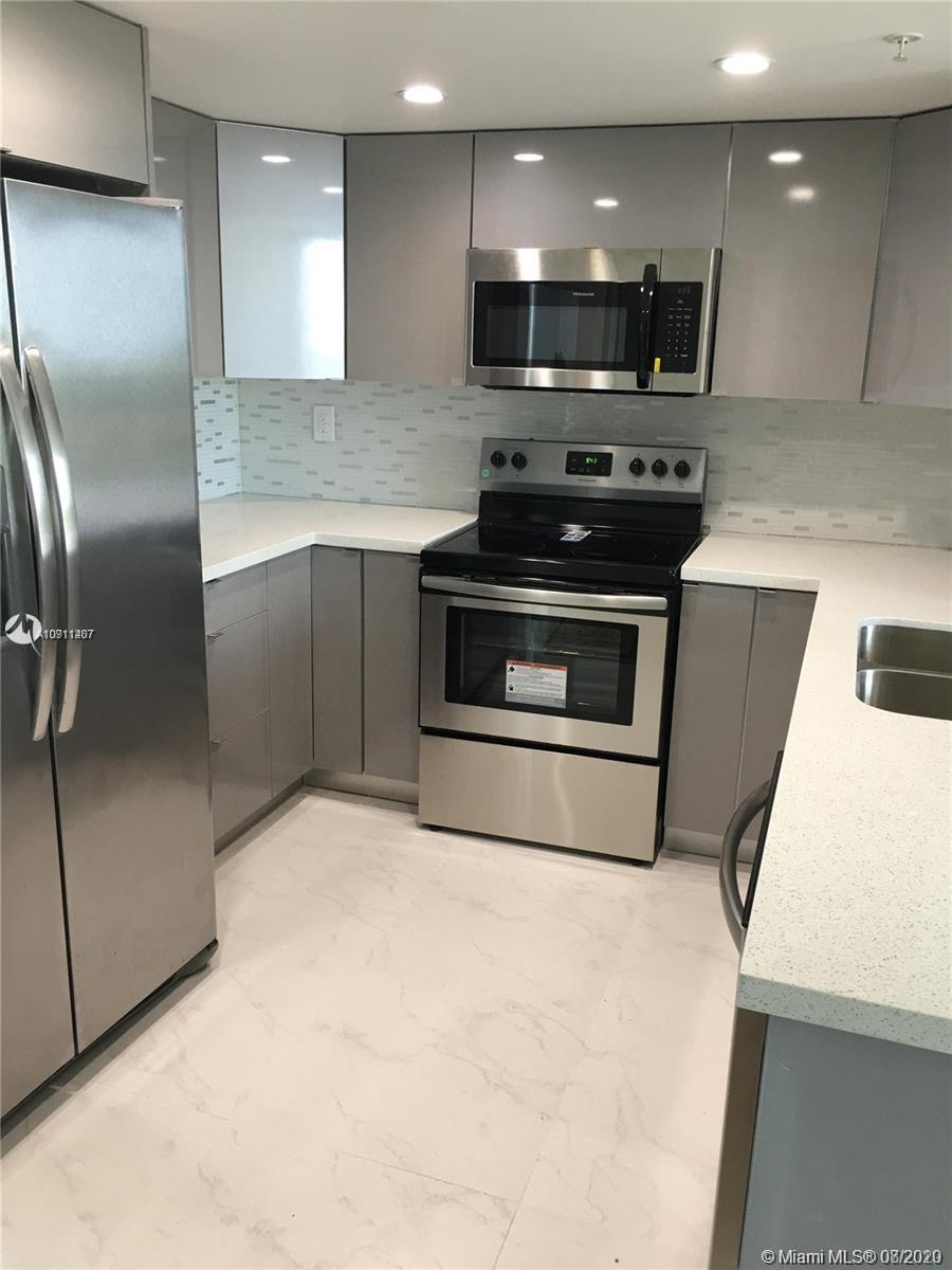 3000 Coral Way, Unit 1207 Miami, FL 33145 - Photo 3 of 8 a kitchen with stainless steel appliances kitchen island granite countertop a stove a refrigerator and a microwave
